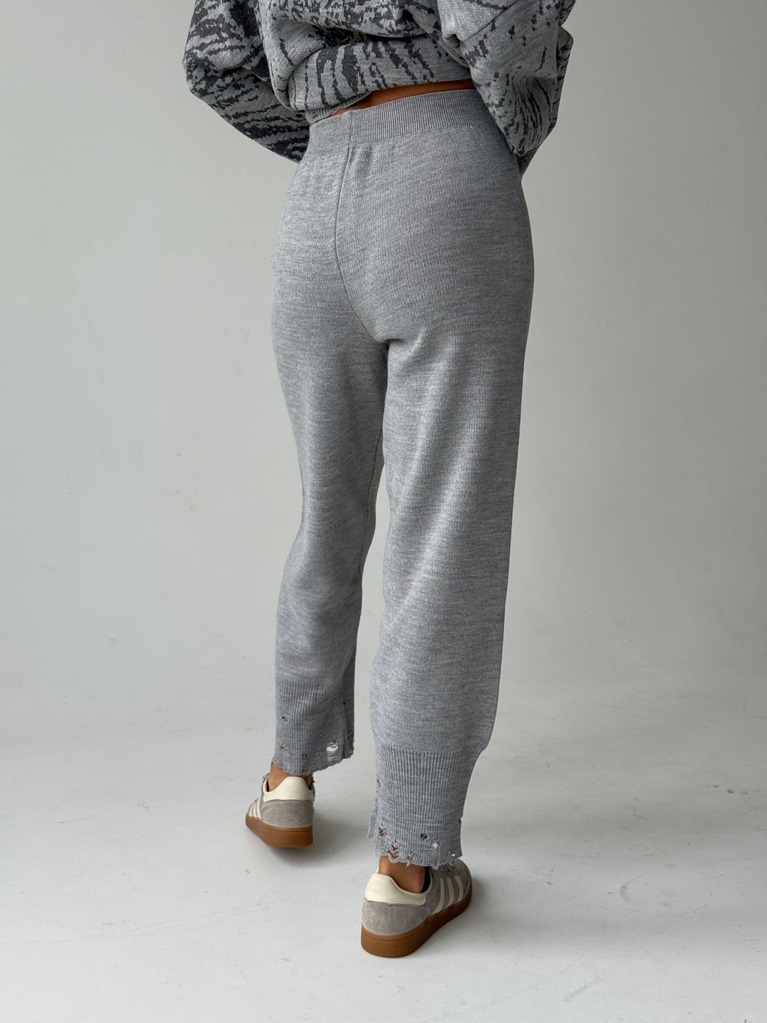 Trikotāžas bikšu kostīms ar uzrakstu un plēsumiem