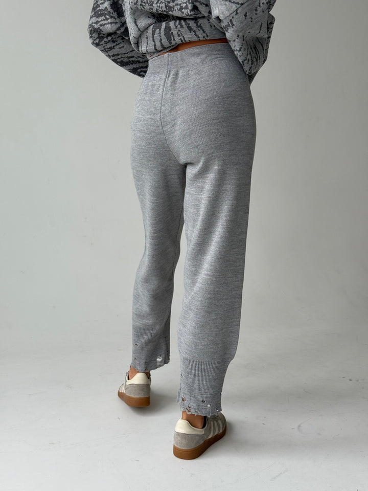 Trikotāžas bikšu kostīms ar uzrakstu un plēsumiem