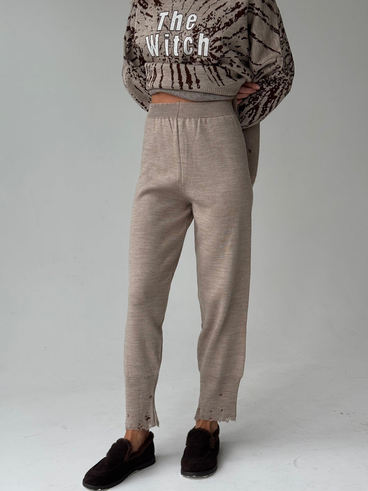 Trikotāžas bikšu kostīms ar uzrakstu un plēsumiem