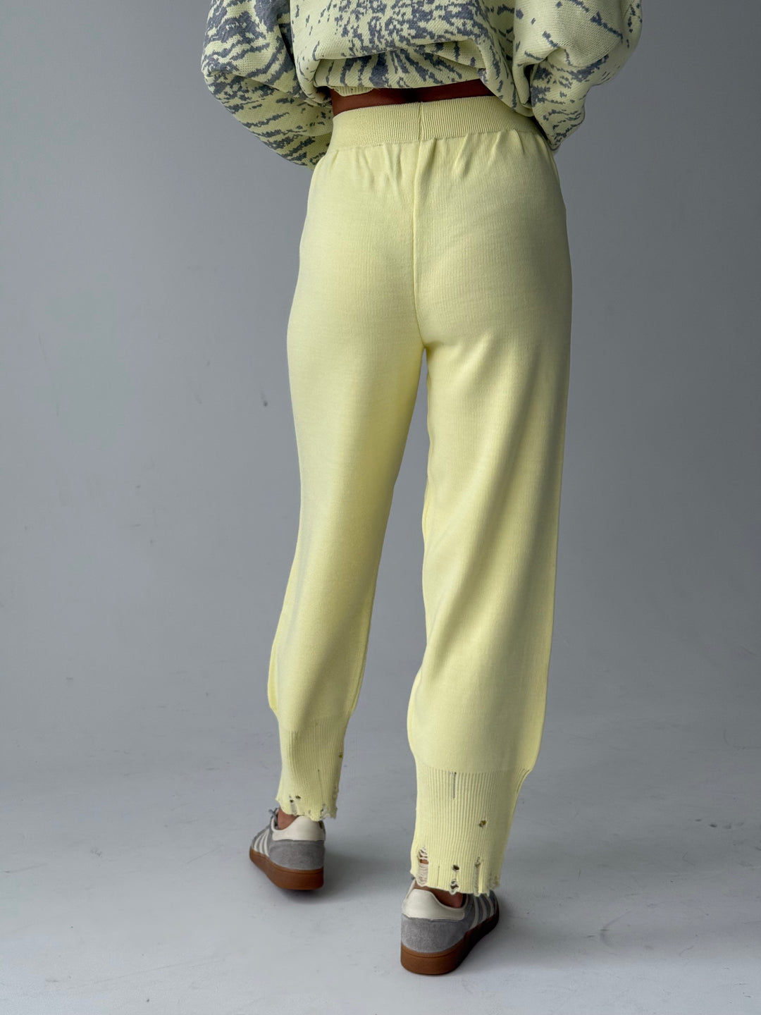 Trikotāžas bikšu kostīms ar uzrakstu un plēsumiem