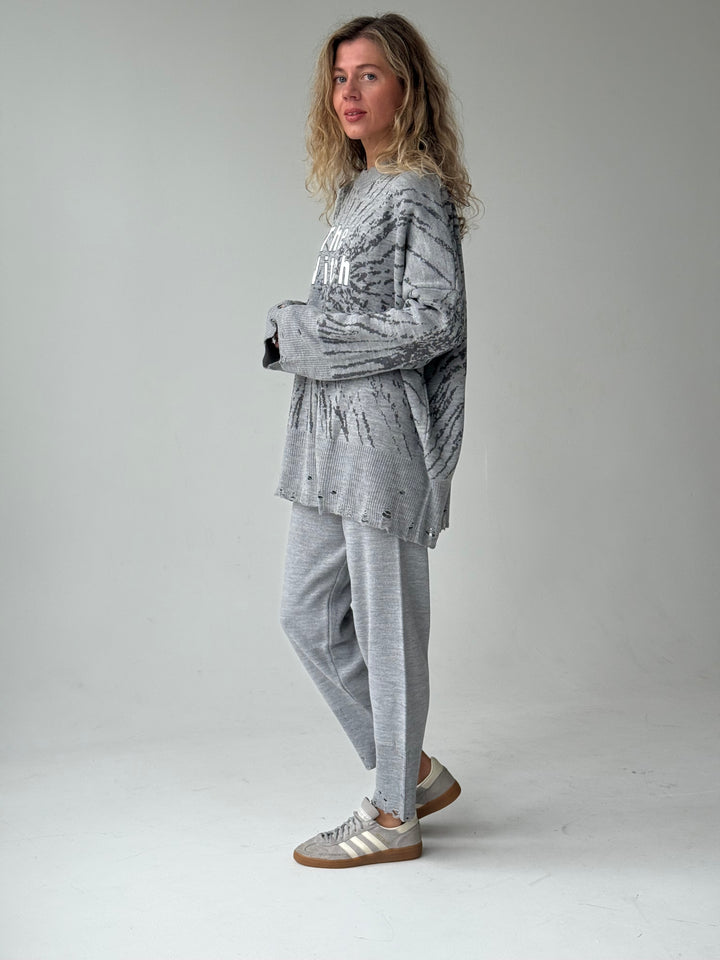 Trikotāžas bikšu kostīms ar uzrakstu un plēsumiem