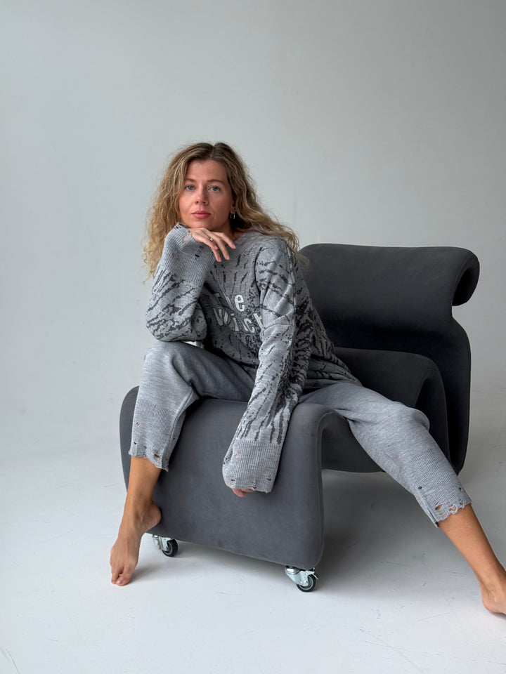 Trikotāžas bikšu kostīms ar uzrakstu un plēsumiem